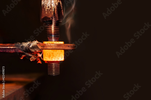 closeup calcining hot metal steel gear parts in a factory induction furnace with smoke