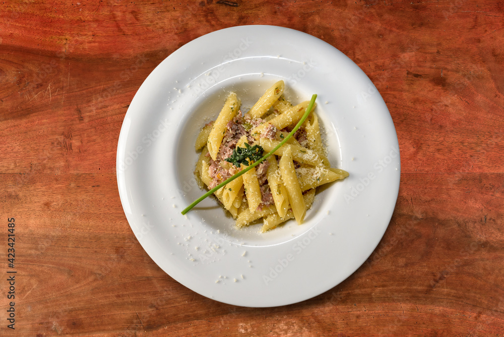 penne pasta with sausage meat sauce and thyme. macaroni Italian Pasta in white dish on wooden table, top view, flat lay penne pasta with sausage meat sauce and thyme. macaroni Italian Pasta in white dish on wooden table, top view, flat lay