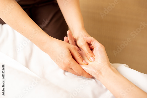 Closeup massage of female hands by physiotherapist. Carpal tunnel syndrome, arthritis, neurological disease concept. Numbness of the hand. Hand massage. © Arina