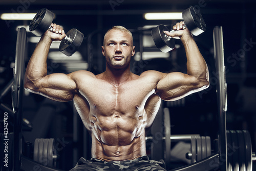 fit man training sholders muscles at gym.