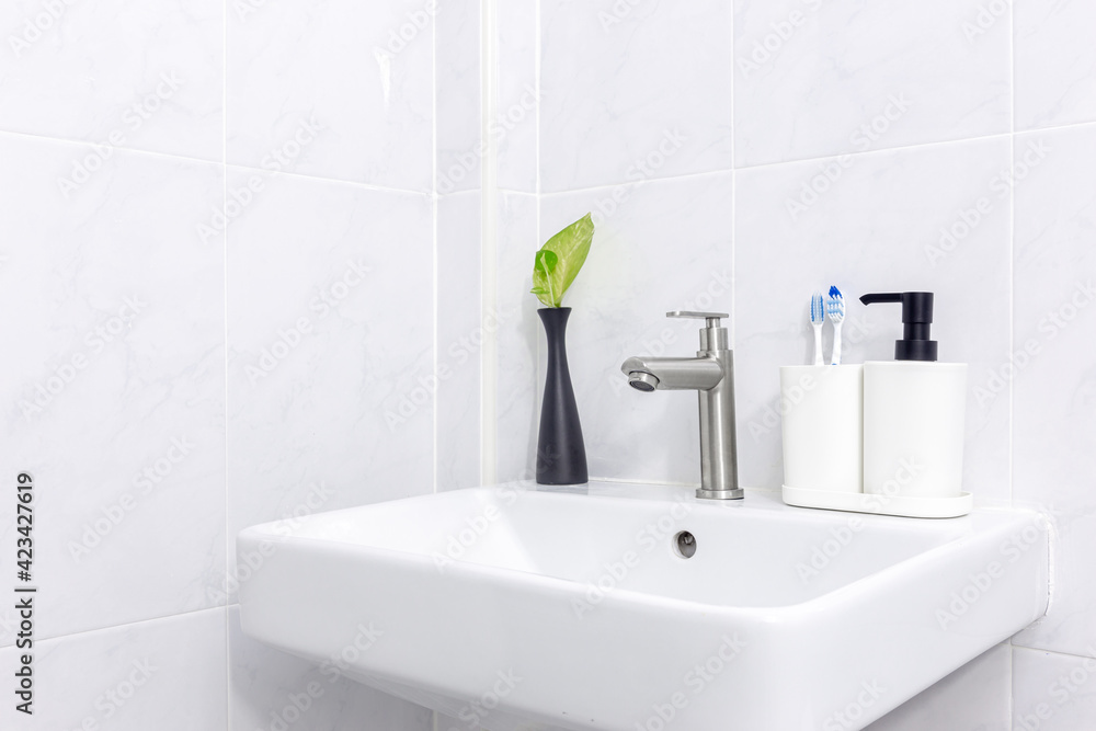 Fototapeta premium White sink and round mirror and toothbrush and white bathroom hand sanitizer bottle.