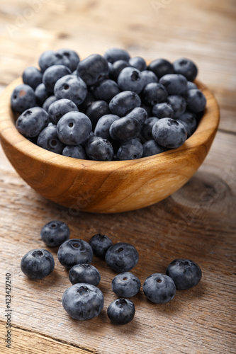 Fresh blueberries in a wooden bowl. Healthy and dietary food concept.