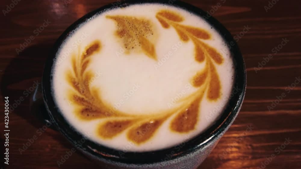 Camera zoom in on cup of coffee on dark wooden table. Coffee Latte Art on milk coffee top. Camera zoom in on cup of coffee on dark wooden table. Coffee Latte Art on milk coffee top.