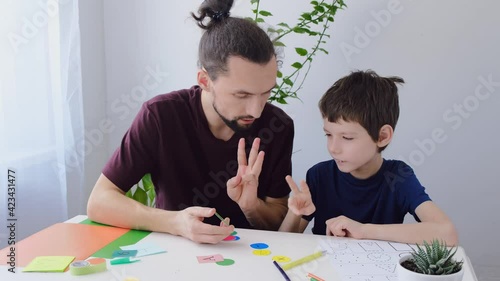 Happy autism boy during therapy with school tutor, learning together