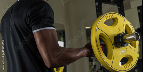 African american athlete exercising with a barbell in the gym