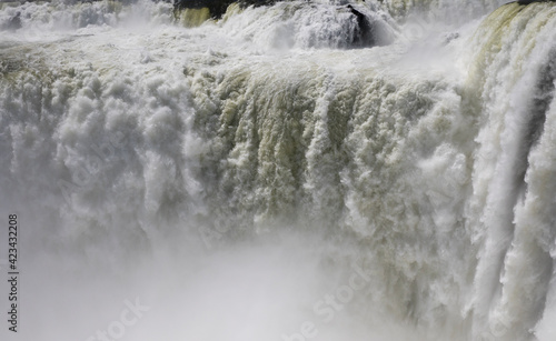 Natural background. Power in water. Closeup view of the famous Iguazu falls in Misiones, Argentina. The mist and falling white water beautiful texture, motion and pattern. 