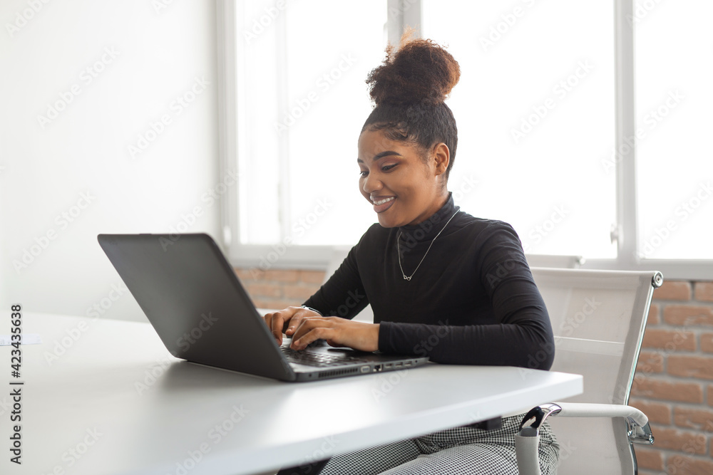 beautiful young african woman at the table with laptop beautiful young african woman at the table with laptop