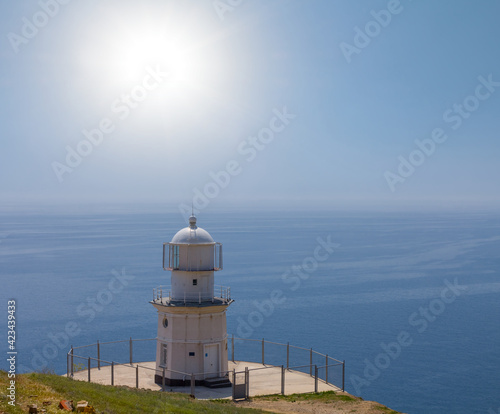 lighthouse on a marine cape at the summer sunny day