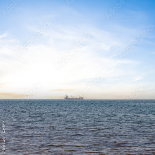 cargo ship in a sea at the sunset, marine transportation scene © Yuriy Kulik