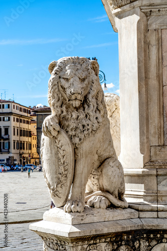 Statue of an heraldic lion, symbol of Florence, called "marzocco", in the platform at the bottom of Dante Alighieri Statue in Santa Croce square, in Florence city center, Tuscany, Italy