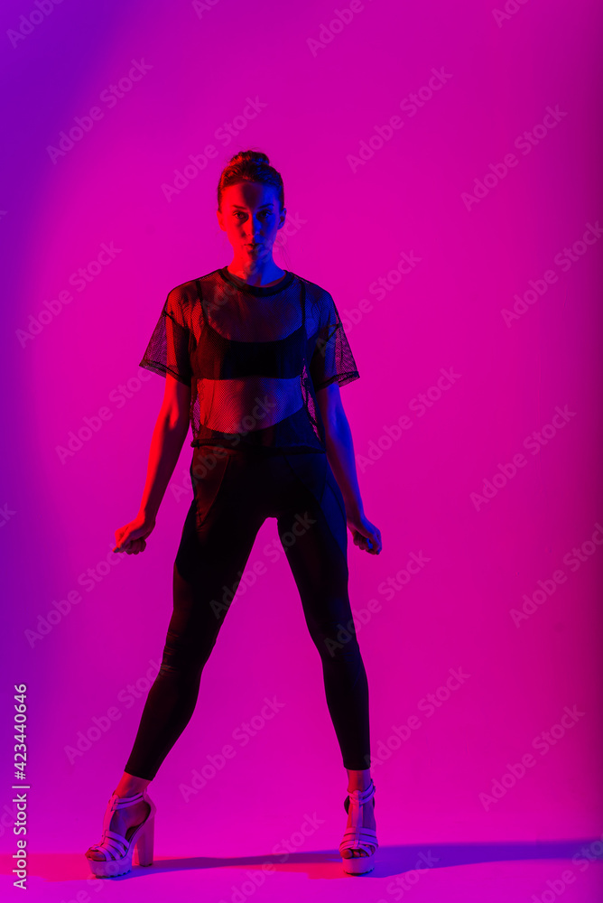 Beautiful young woman wearing sexy high heels and black clothes while dancing in pole dance studio Beautiful young woman wearing sexy high heels and black clothes while dancing in pole dance studio