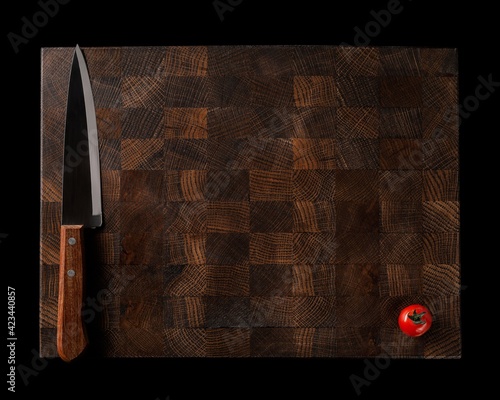 Handmade wooden chopping board with fresh vegetables on a dark background. space for labels