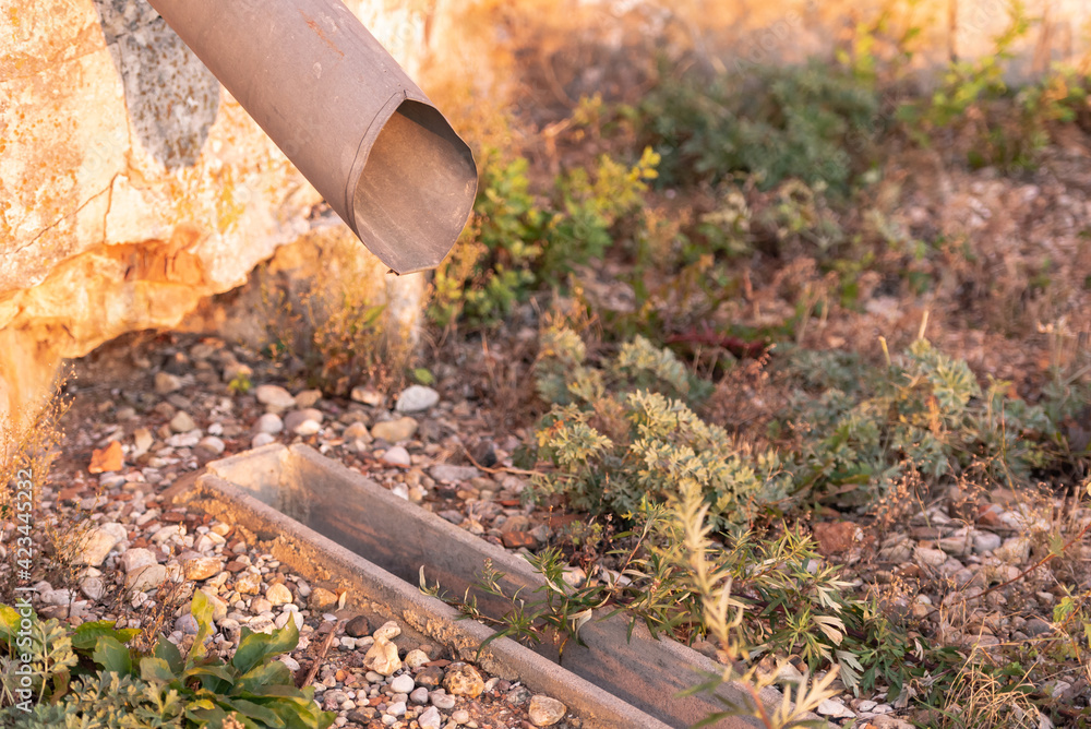 Obraz premium Storm sewer with grate. Drainage of rainwater into a storm ditch. How to make the drainage of the site and the drainage of water