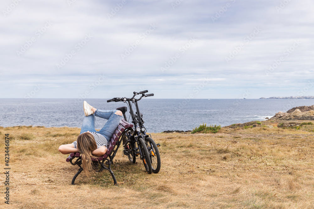 Fototapeta premium woman lying on a bench relaxing on vacation