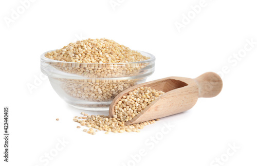 Glass bowl and wooden scoop with quinoa on white background