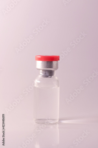 Doctor holding vial with vaccine against Covid-19 on light background, closeup. Coronavirus Vaccine / Corona virus Vaccine concept with syringe. Vaccine Concept of fight against coronavirus. 