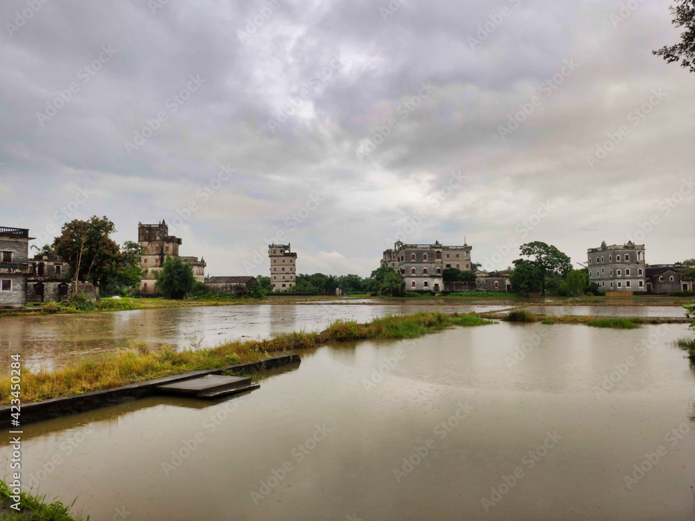Kaiping diaolou and villages. Сoncrete watchtowers. Houses and flooded rice fields. Cloudy weather. China. Asia	