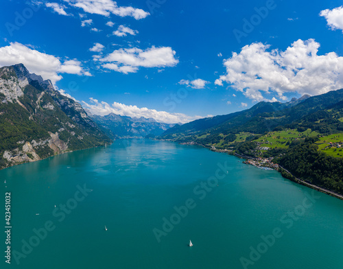 Aerial drone shot over beautiful Walensee  lake  Switzerland  with boats and yacht sailing through turquoise waters 