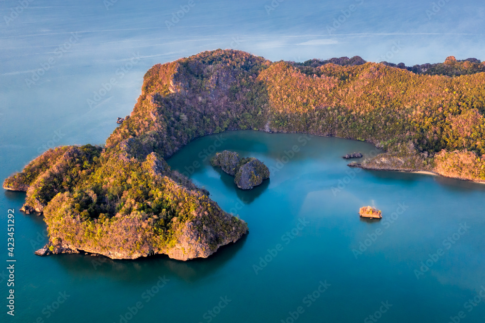 Langkawi Malaysia aerial ocean cove during the morning golden hours. Soft blue ocean waters and several islands protected by the forested peninsula