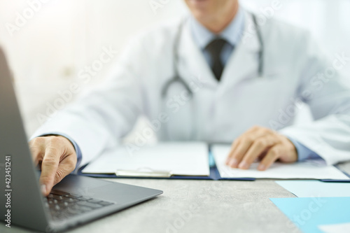 Male doctor hands using modern laptop in clinic