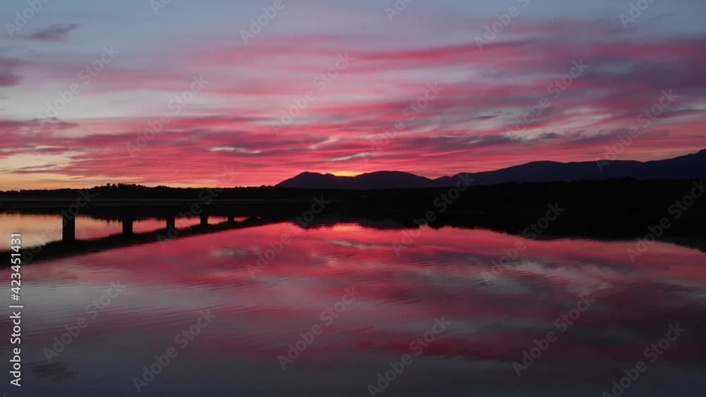 Toma aérea de un atardecer sobre un puente del Norte de Madrid, junto a un embalse grabado en 4k desde un dron Toma aérea de un atardecer sobre un puente del Norte de Madrid, junto a un embalse grabado en 4k desde un dron