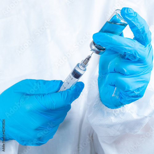 covid-19 sars-cov-2 vaccination: a health worker with a vaccine and a syringe in his hands