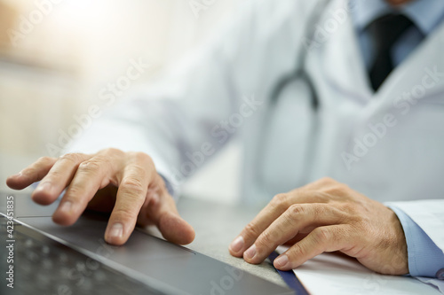 Male doctor hands using modern notebook in clinic