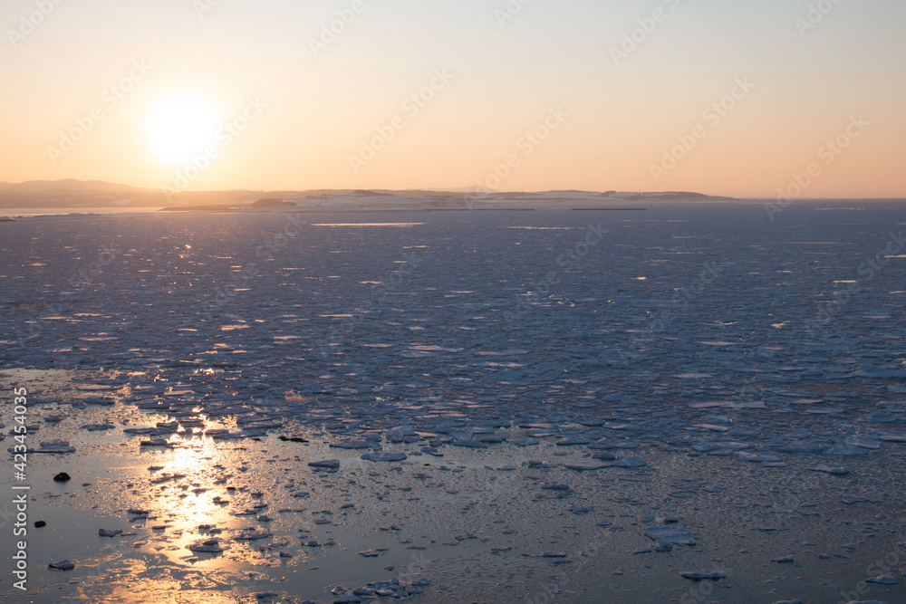冬の網走市能取岬 夕日と流氷の風景