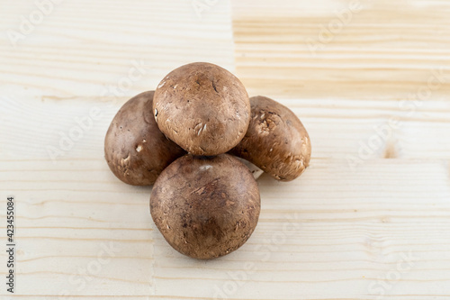 mushroom caps champignons brown stacked on light beige