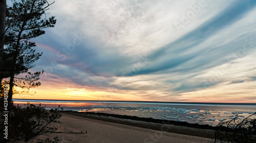 Sunset on the beach with pieces of ice floating over a sea