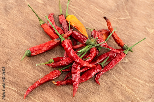 scattering of red and yellow chili peppers on wooden background close-up