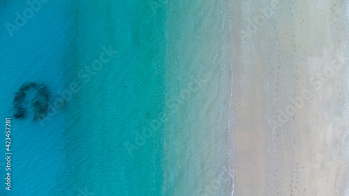 美しいケラマブルーの海と砂浜に白波が立つドローン俯瞰写真