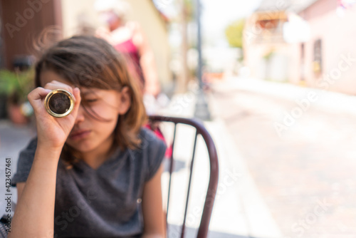Fototapeta Naklejka Na Ścianę i Meble -  Young girl looking through a spyglass in a city