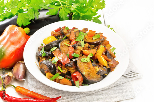 Ragout with eggplant and pepper on wooden board