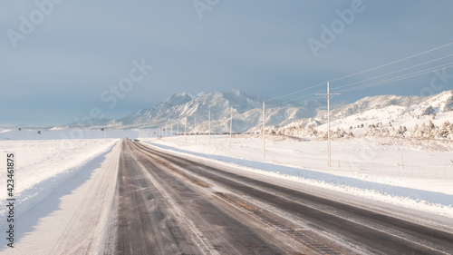 Winter road with mountains in the background near Boulder, Colorado, USA