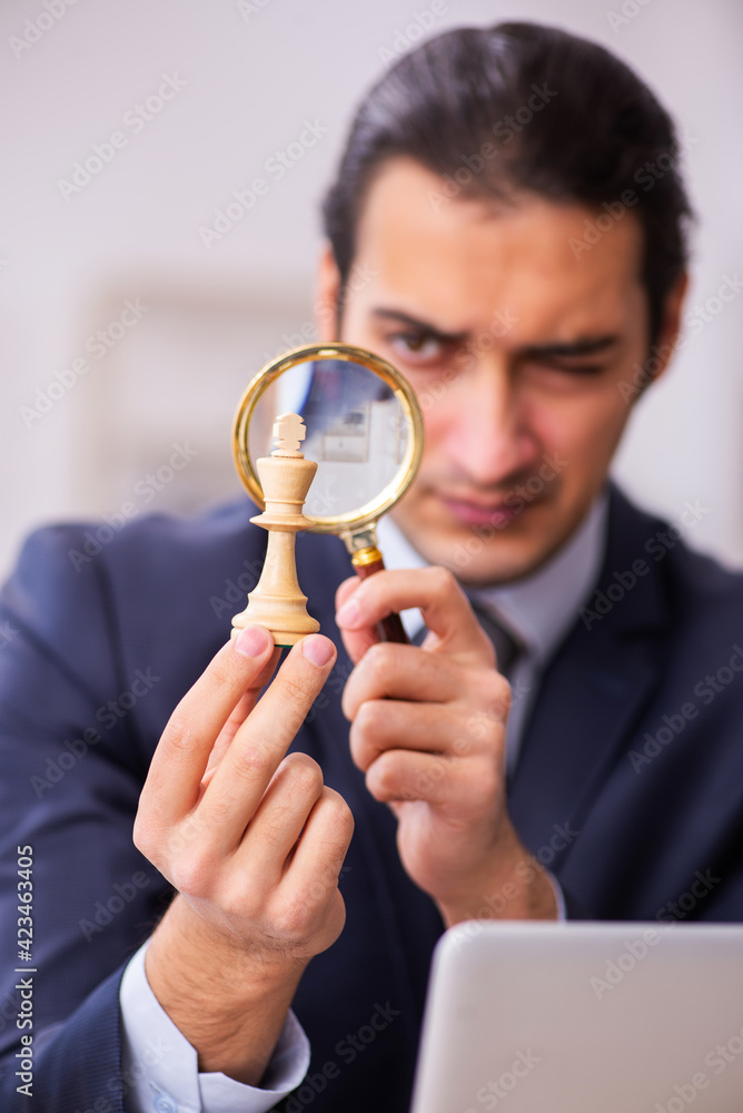 Young male employee playing chess at workplace Young male employee playing chess at workplace