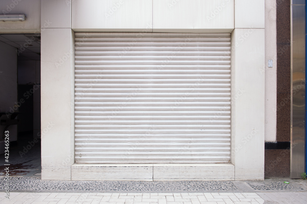 A closeup shot of automatic metal roller door used in factory, storage, garage, and industrial warehouse. The corrugated and foldable metal sheet offer space saving and provide urban and rustic feel A closeup shot of automatic metal roller door used in factory, storage, garage, and industrial warehouse. The corrugated and foldable metal sheet offer space saving and provide urban and rustic feel