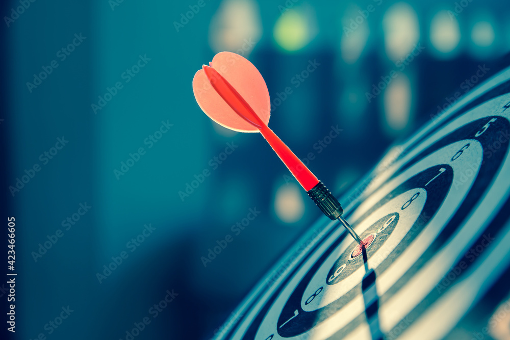 Close-up the bullseye or bulls eye target or dart board has dart arrow throw hitting the center of a shooting for business targeting and aim to winning goals concepts Close-up the bullseye or bulls eye target or dart board has dart arrow throw hitting the center of a shooting for business targeting and aim to winning goals concepts