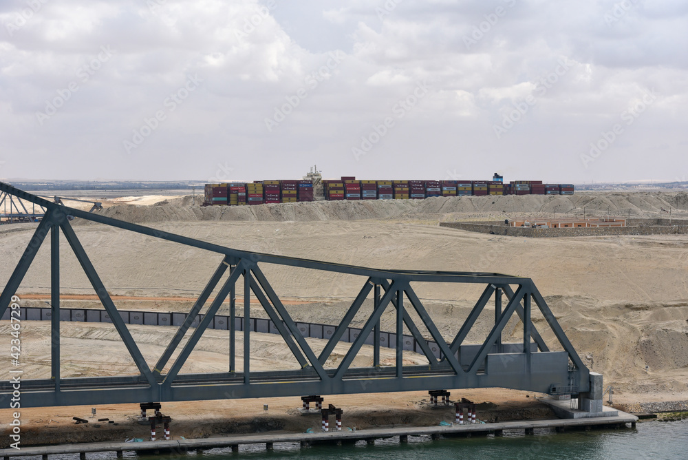 Landscape of Suez Canal, view from transiting cargo ship. Bridge construction on the Canal bank. 
