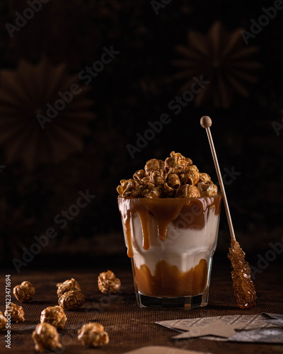 Delicious caramel milkshake with sweet popcorn on a dark background.