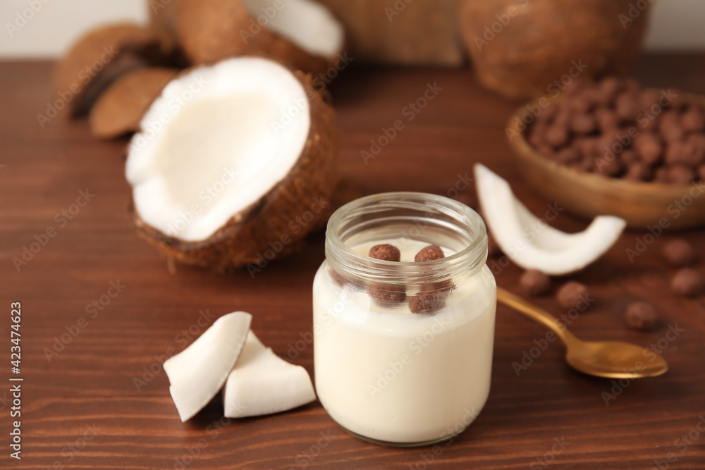 Jar of tasty coconut yogurt on wooden background Jar of tasty coconut yogurt on wooden background