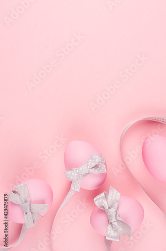 Pink easter eggs with grey curved ribbons on pastel pink background, vertical, stories. © finepoints