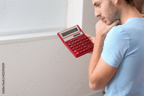 Young man with calculator a...