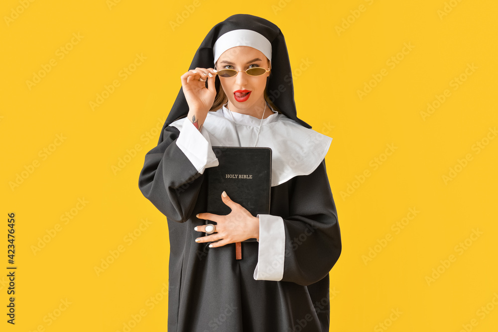 Sexy nun with Bible on color background Sexy nun with Bible on color background