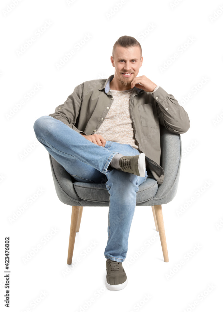 Young man sitting in armchair on white background