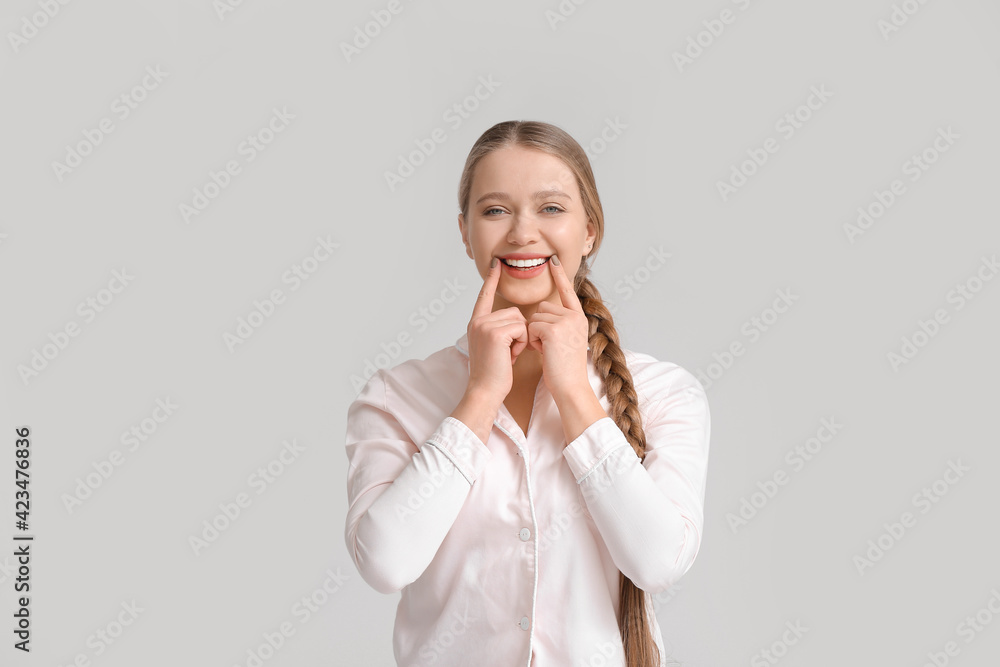 Beautiful smiling young woman on grey background Beautiful smiling young woman on grey background