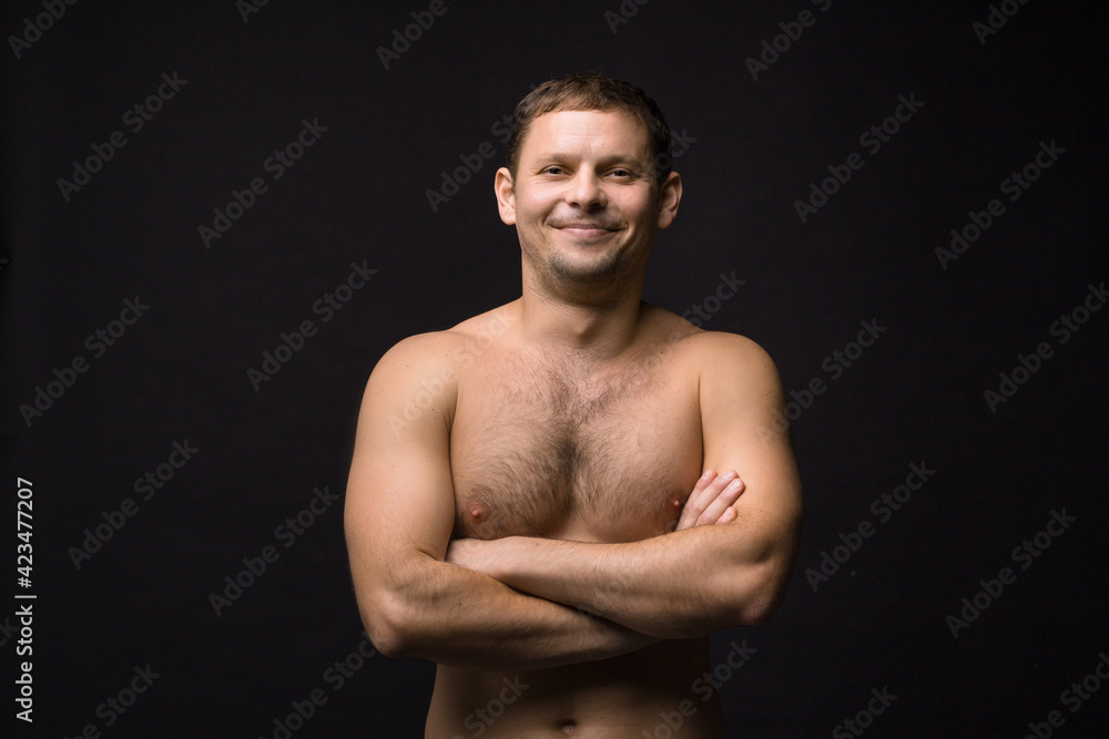 Handsome smiling man on the black background. Muscular and athletic. Man portrait. Male model in studio Handsome smiling man on the black background. Muscular and athletic. Man portrait. Male model in studio