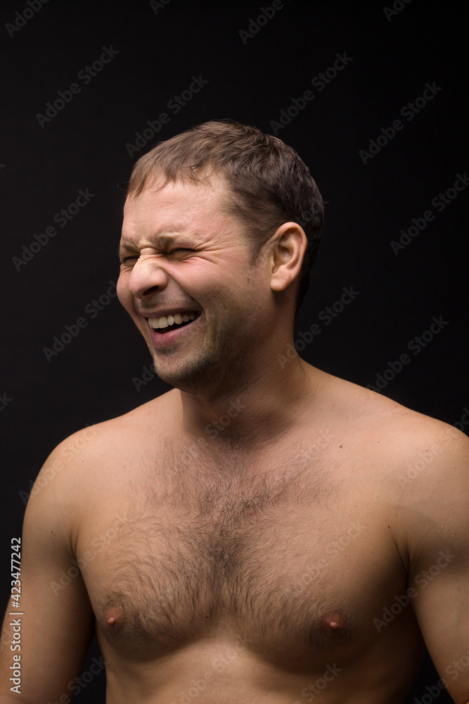 Handsome smiling man on the black background. Muscular and athletic. Man portrait. Male model in studio Handsome smiling man on the black background. Muscular and athletic. Man portrait. Male model in studio