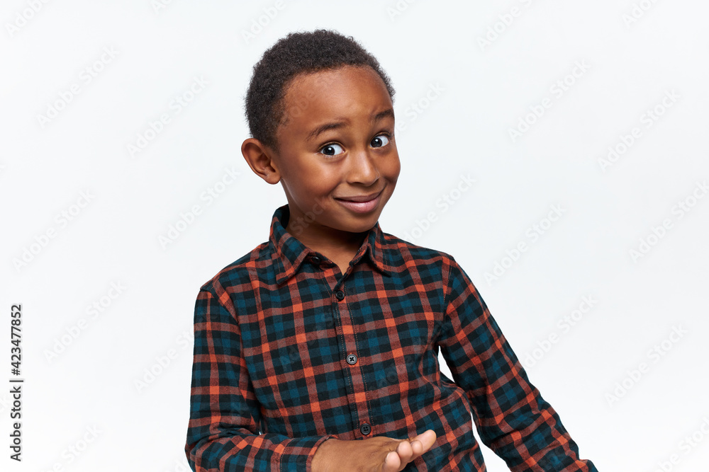 Are you serious? Portrait of astonished curious little dark skinned boy with short curly hair staring at camera in full disbelief, raising eyebrows. Human facial expressions, emotions and reaction Are you serious? Portrait of astonished curious little dark skinned boy with short curly hair staring at camera in full disbelief, raising eyebrows. Human facial expressions, emotions and reaction