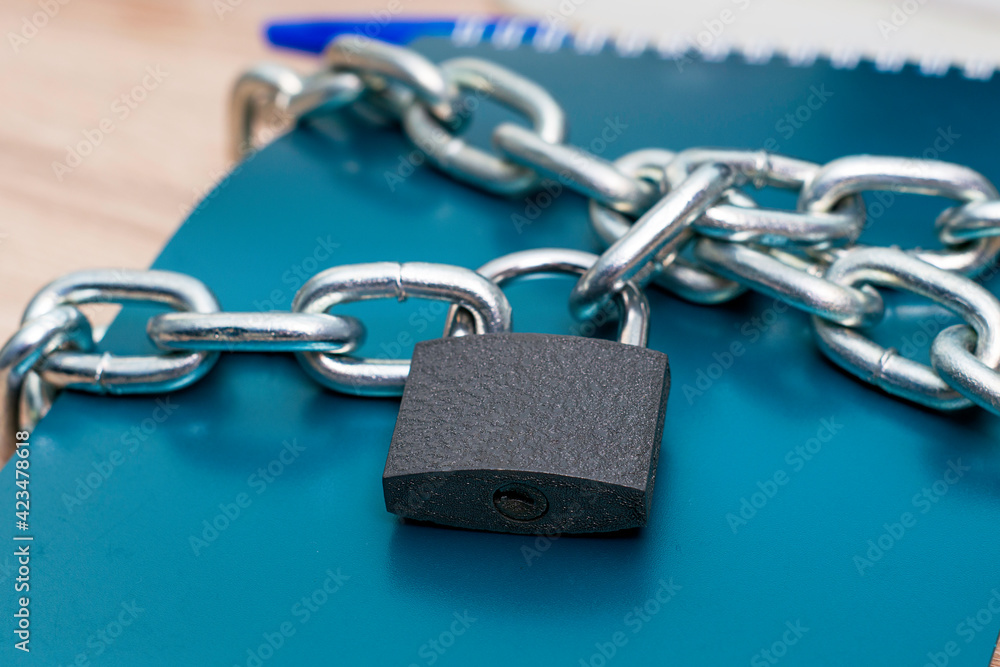 the notebook for writing is wrapped with an iron chain closed with a lock concept information protection data protection the notebook for writing is wrapped with an iron chain closed with a lock concept information protection data protection